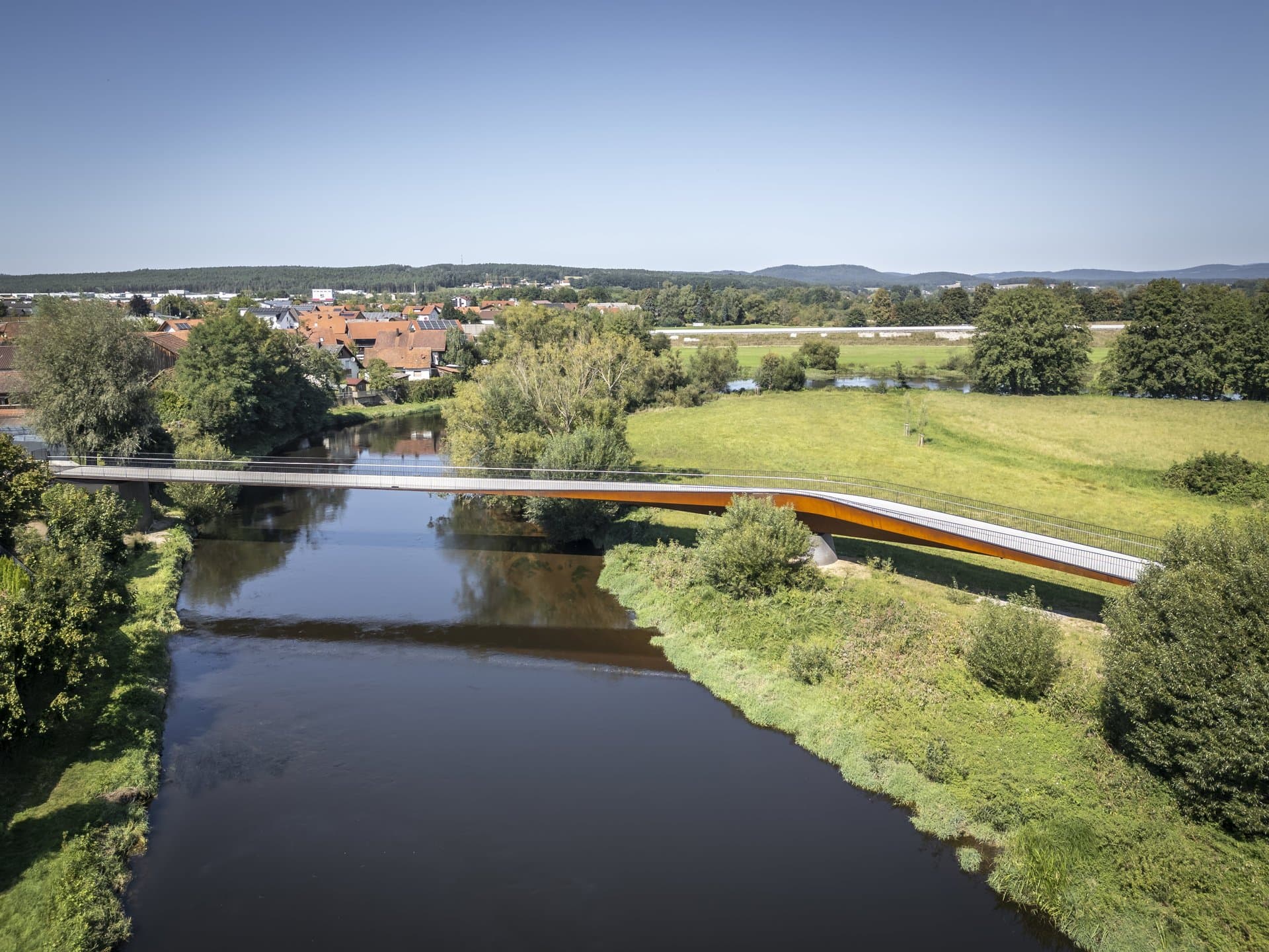 Die Brücke als feine Linie im Gefüge aus Natur, Stadt und Wasserlauf © FOTOGRAFIEIMRAUM, Aron Jungermann